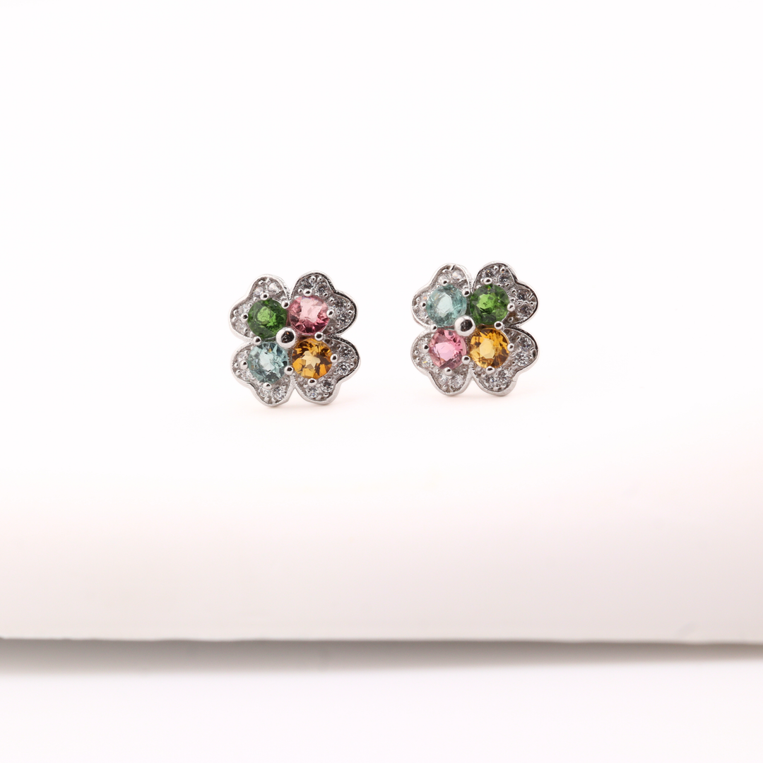 Pair of flower-shaped earrings with Tourmaline gemstones on a white background