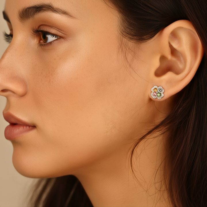 Close-up of a woman wearing a floral earring with Tourmaline stones.